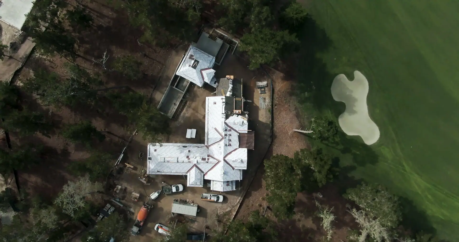Aerial view of a home under construction beside a golf fairway