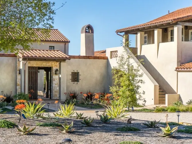 Stucco villa with clay-tile roofs and a drought-tolerant agave garden