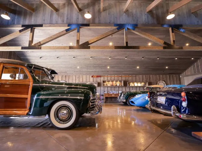 Garage with exposed timber trusses, polished concrete and a collection of vintage cars