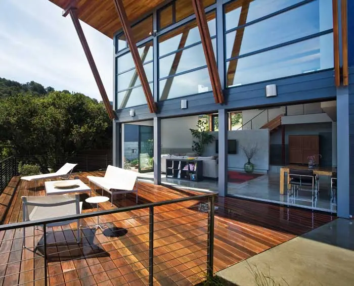 Steel-framed glass wall and angled timber roof over an ipe deck