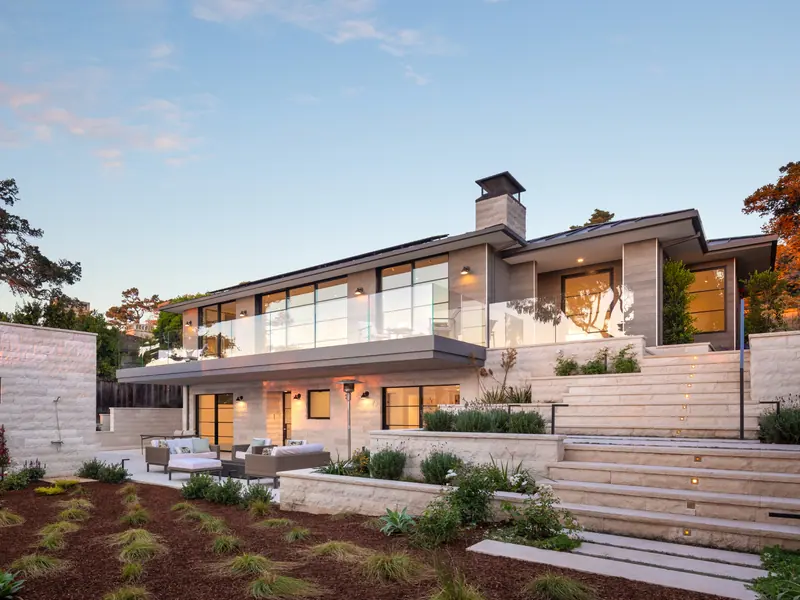 Contemporary hillside home with terraced limestone steps and native plantings at sunset