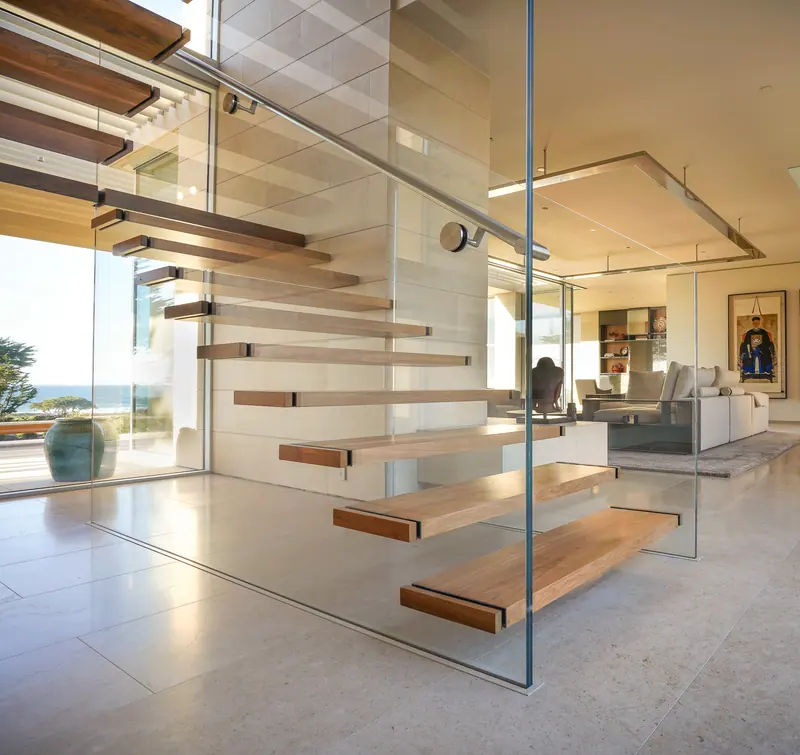 Floating timber stair treads inside a glass enclosure