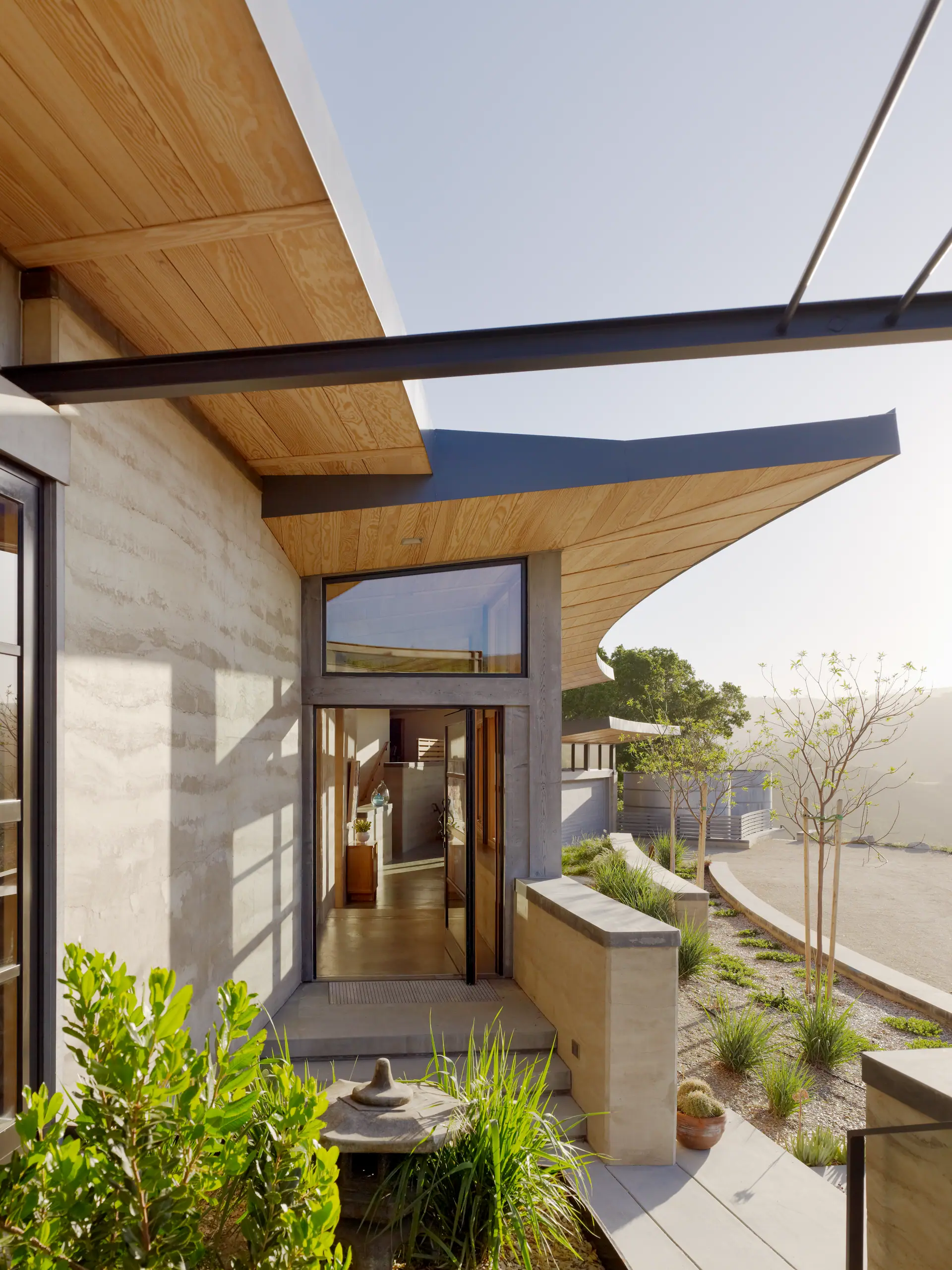Concrete and timber entry with a cantilevered roof overlooking the hills