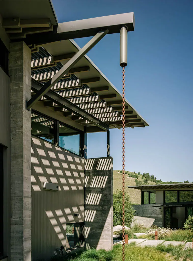 Shadow-casting timber screen and a copper rain chain above a stepped garden