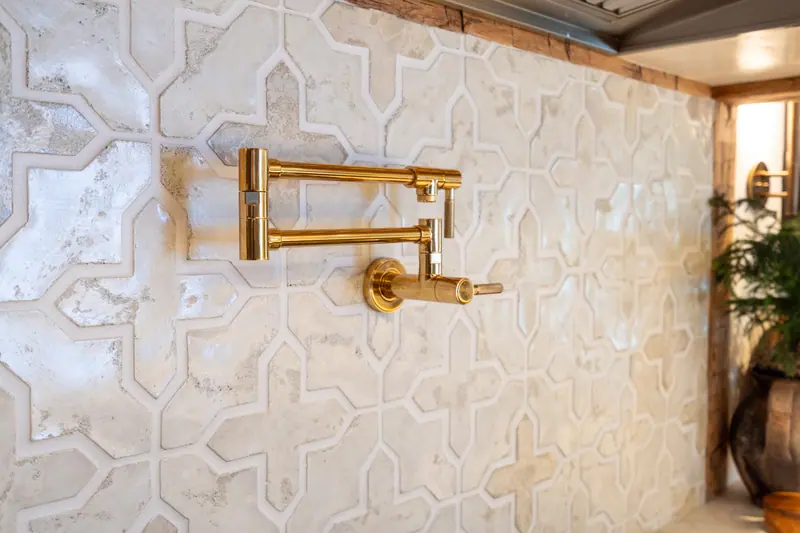 Brass pot filler against a hand-glazed Moorish tile backsplash