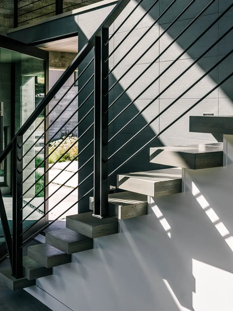 Steel stair with horizontal railings in a shadow-filled stairwell