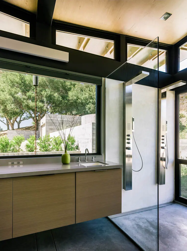 Bathroom with a floating vanity and glass shower looking out to trees